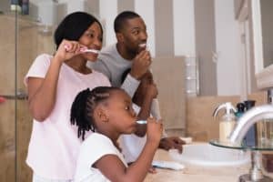 Parents brushing their teeth with their child