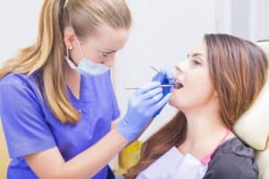 dental hygienist looking at a patient's teeth