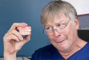 man looking at dentures