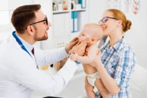 A dentist examining an infant's mouth
