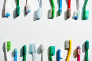 Image with many different colors and types of toothbrushes.