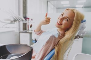 Woman giving thumbs up during preventive dental visit in Boulder
